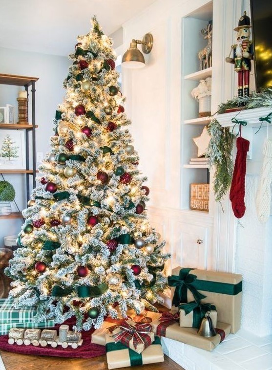 a flocked Christmas tree with lights, red and green ornaments and green ribbons is a very cute and chic idea