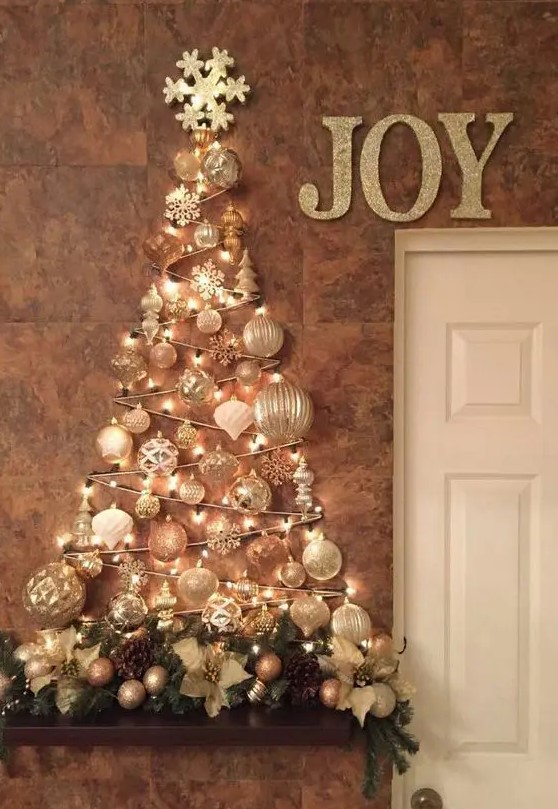 a glam wall-mounted Christmas tree done with lights and white and silver ornaments of various shapes over the mantel