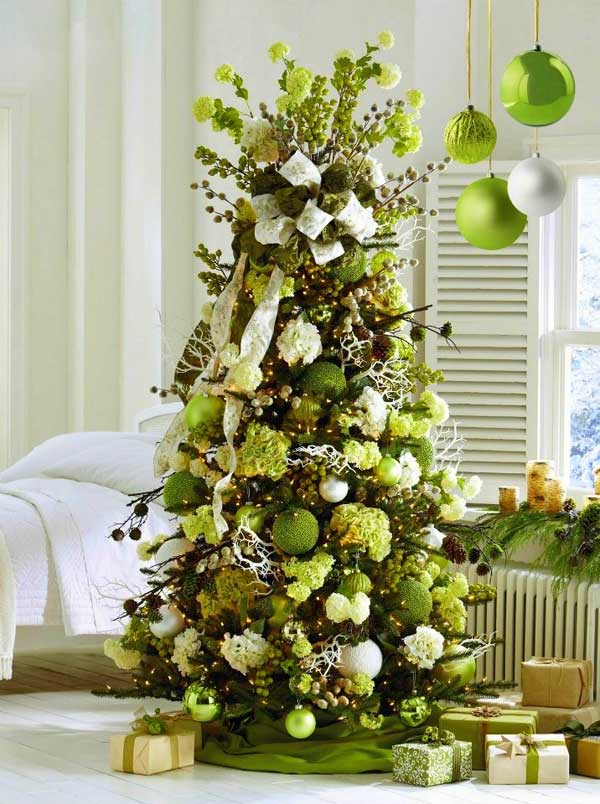 a green Christmas tree with white and green blooms and ornaments, branches, ribbons and pinecones is a chic idea