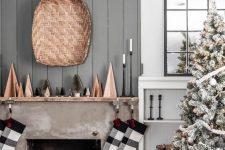 a laconic Scandi-inspired Christmas mantel with wooden and bottle cleaner trees, plaid stockings and candles in tall candleholders