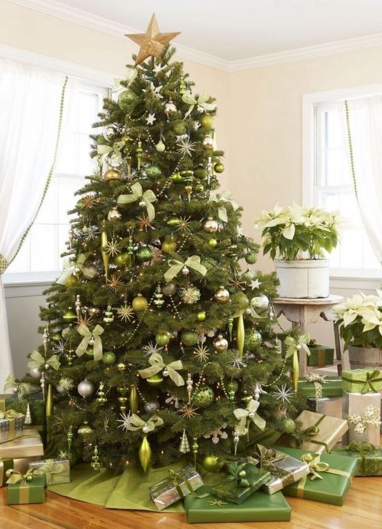 a large Christmas tree decorated with light green and silver ornaments, silver beads and light green bows plsu green gift boxes under the tree