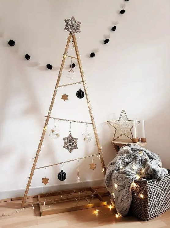 a large frame Christmas tree with lights, black, silver, clear and white ornaments and a large snowflake on top