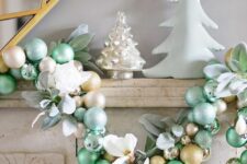 a lovely light green, gold and silver ornament garland with leaves and white blooms is a chic and stylish idea for Christmas