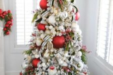 a lovely modern Christmas tree decorated with red and green ornaments, branches and berries, a wooden marquee light topper