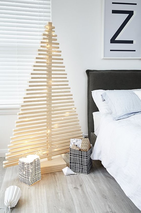 a minimalist plywood Christmas tree decorated only with lights is a great idea for a minimalist fan