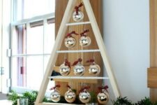 a modern A-framed Christmas tree with ornaments hanging inside is a stylish idea to make yourself and add interest to the space