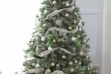 a neutral Christmas tree with lots of metallic ornaments and plaid ribbons looks very calm and cute