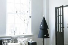 a paper Christmas tree in black and white with stars on a pole is a cool idea for a monochromatic or minimalist interior