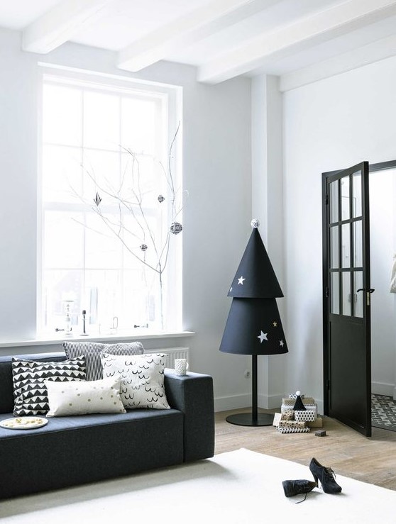 a paper Christmas tree in black and white with stars on a pole is a cool idea for a monochromatic or minimalist interior