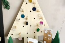 a plywood tabletop Christmas tree with perforations and colorful mini ornaments is a pretty idea for holidays