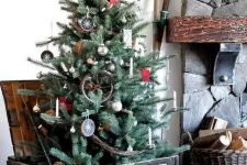 a rustic Christmas tree with antlers, wood slice ornaments, a twig star on top, branches and an antique crate as a base