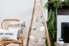 a stained frame Christmas tree with white, gold ornaments hanging on copper railing is a cool and fresh idea