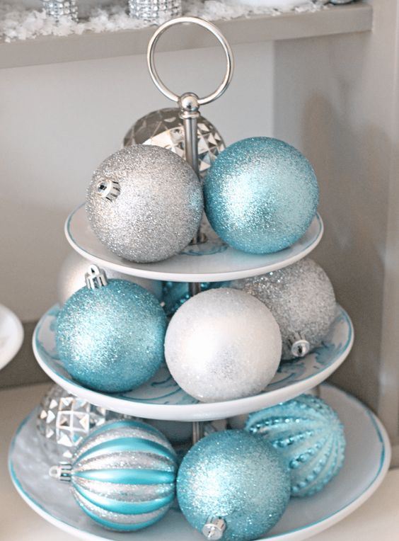 a stand with silver and blue glitter Christmas ornaments is a nice centerpiece or some other decoration