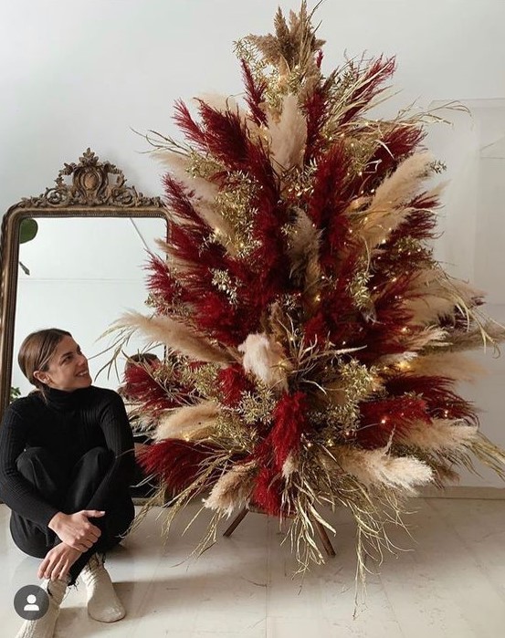 a super bold neutral and burgundy pampas grass Christmas tree decorated with gilded branches and lights is cool for the holidays