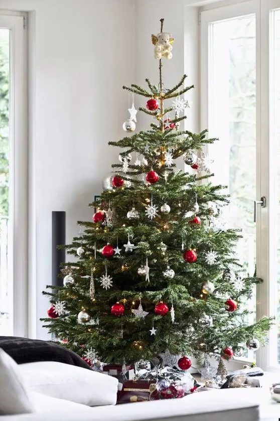 a traditional Christmas tree with white, red, metallic ornaments, balls, snowflakes and stars