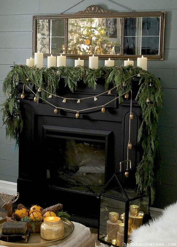 a vintage Christmas mantel with an evergreen garland, bell garlands and pillar candles is timeless classics that will always look chic