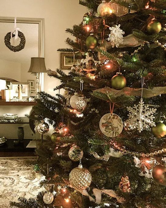 a vintage Christmas tree with green and white ball ornaments, snowflake and silver ones plus lights