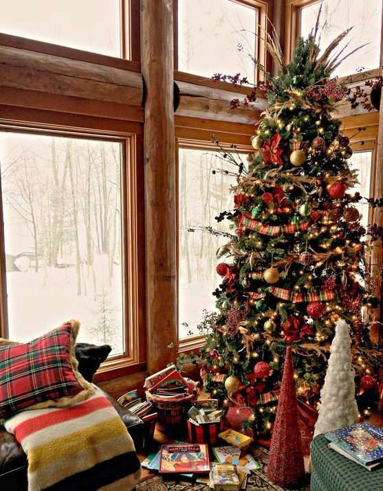 a vintage Christmas tree with lights, red, gold and green ornaments, twigs, berries and herbs