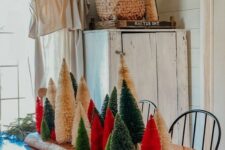 a wooden plank with a colorful bottle brush tree forest is a gorgeous and fresh Christmas centerpiece idea