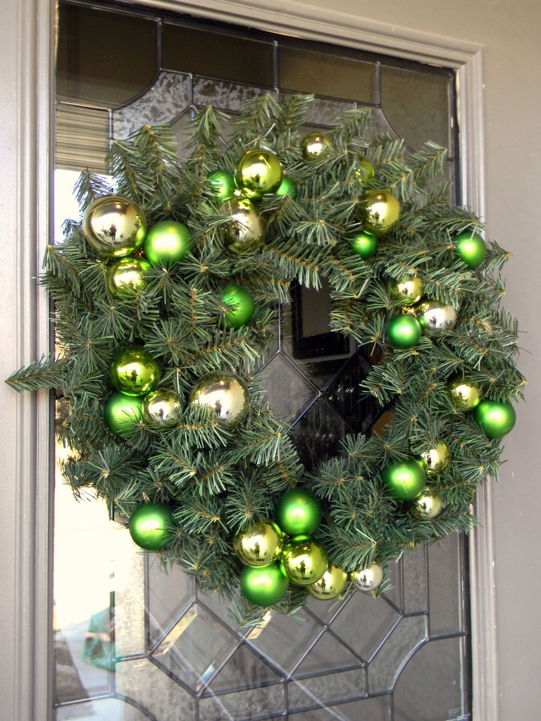 an evergreen Christmas wreath with green and gold ornaments is a stylish idea for the holidays