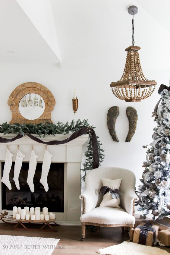 an exquisite vintage Christmas mantel with an evergreen and brown ribbon garland, white stockings, a wooden clock with NOEL letters