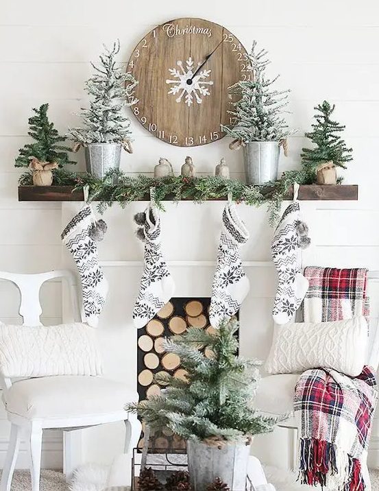 black and white stockings, snowy evergreen trees, an evergreen garland and a wooden Christmas clock for a cozy woodland Christmas look