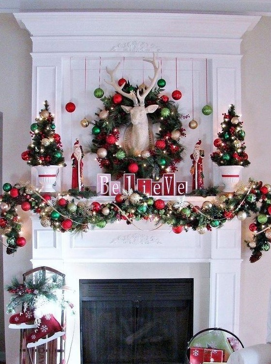 cozy and chic Christmas decor with red and green ornament garlands and a wreath, mini trees and lights, a deer head and red skates