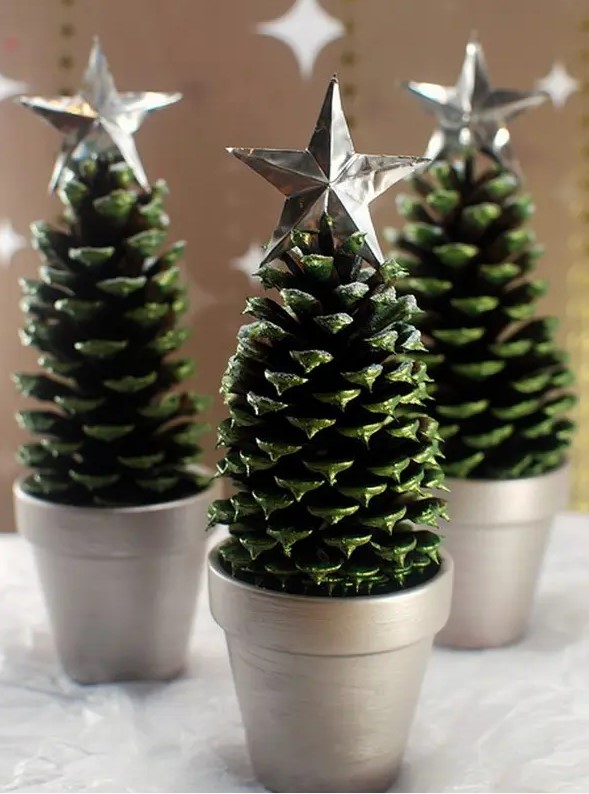 large pinecones painted green, in silver planters and topped with silver stars are great alternative tabletop Christmas trees