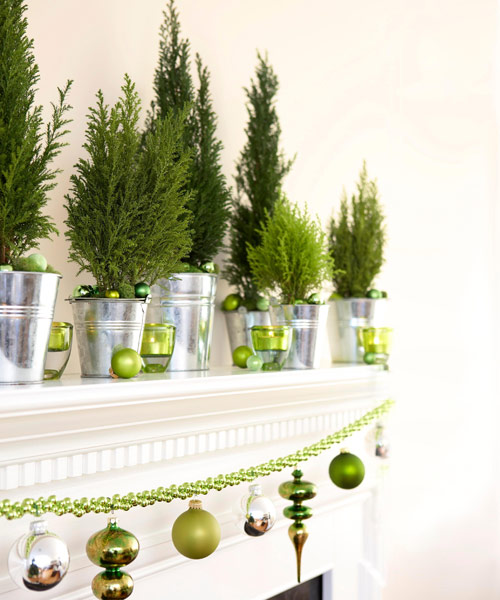mantel decor with potted Christmas trees and green Christmas ornaments and a garland is amazing for the holidays