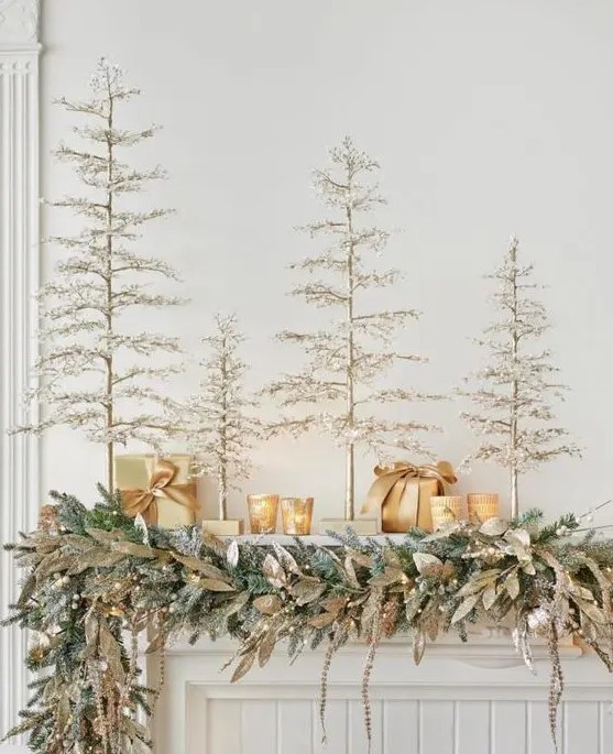 multiple faux Christmas trees, candleholders and an evergreen garland with magnolia leaves