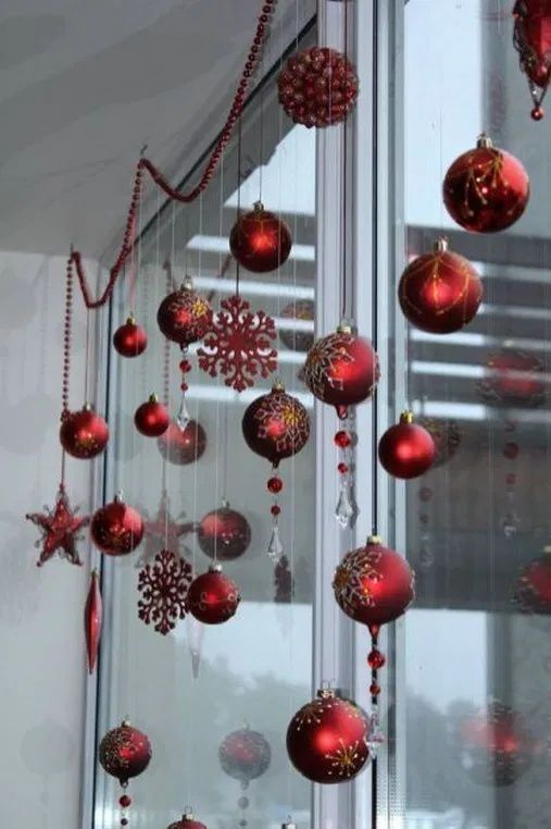 red Christmas ball and snowflake ornaments and beaded garlands to decorate a window