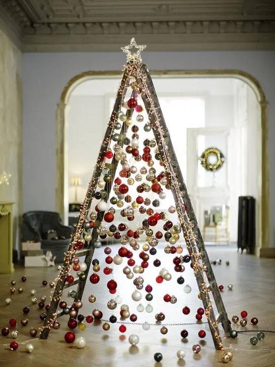 take a usual ladder and cover it with lights, then attach Christmas ornaments on various heights to form a creative tree