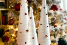 very easy Christmas decor – white yarn wrapped cones decorated with bold bells and beads that are super cool