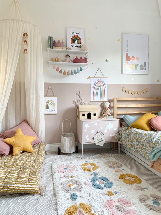 a beautiful Scandinavian girl's room with mauve color block walls, a stained bed with printed bedding, a printed rug and a teepee with pillows