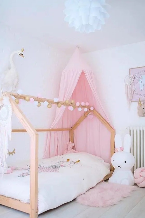 a beautiful kid's room with a canopy bed, a pink canopy, a pink rug and pillow, a fluffy pendant lamp