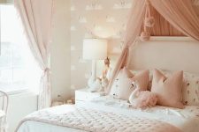 a blush and white girl’s bedroom with pink flamingo wallpaper, a white bed with pink and white bedding, a pink canopy and a crystal chandelier