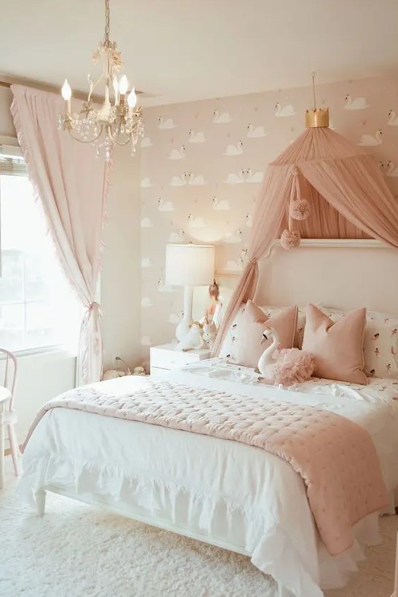 a blush and white girl's bedroom with pink flamingo wallpaper, a white bed with pink and white bedding, a pink canopy and a crystal chandelier