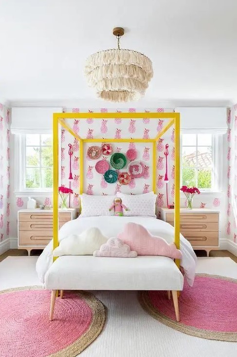 a bright girl's room with bright pineapple print wallpaper, a neon yellow canopy bed, chic nightstands, pink rugs and pink pillows