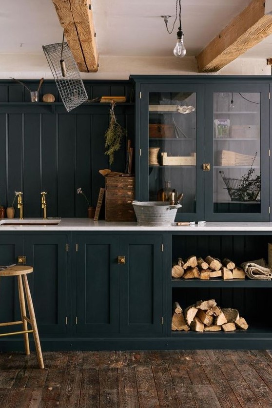a graphite grey shaker style kitchen with white countertops, wooden beams on the ceiling and brass touches for more elegance