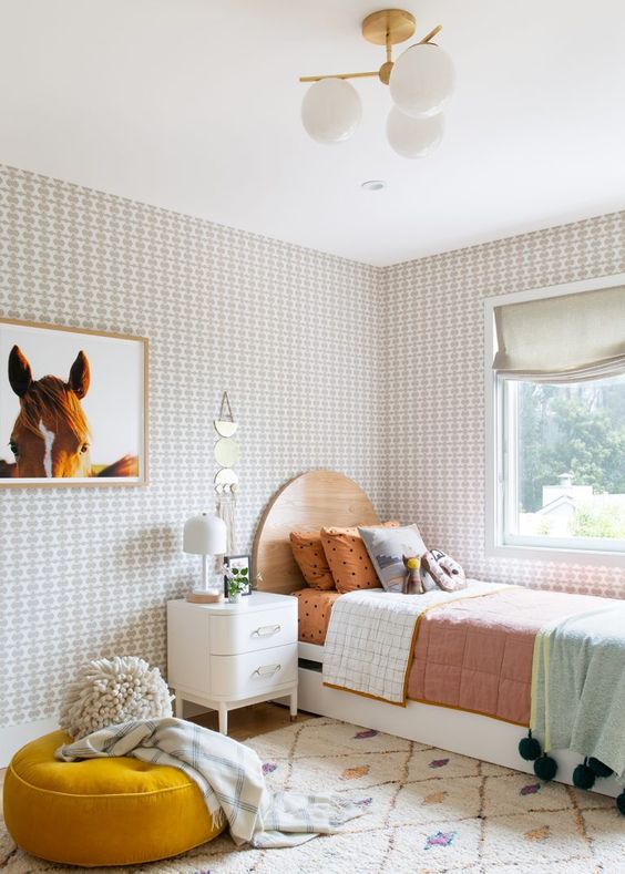 a mid-century modern girl's room with a white and stained bed with bold bedding, printed wallpaper, a horse artwork, a mustard cushion and a creamy nightstand