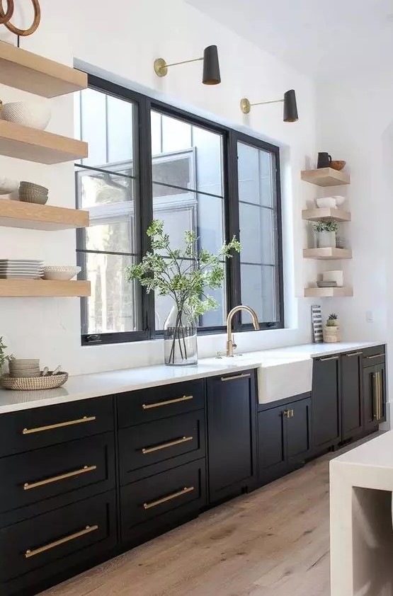 a modern farmhouse kitchen with black shaker cabinets, white countertops and statement flaoting shelves plus black and gold sconces