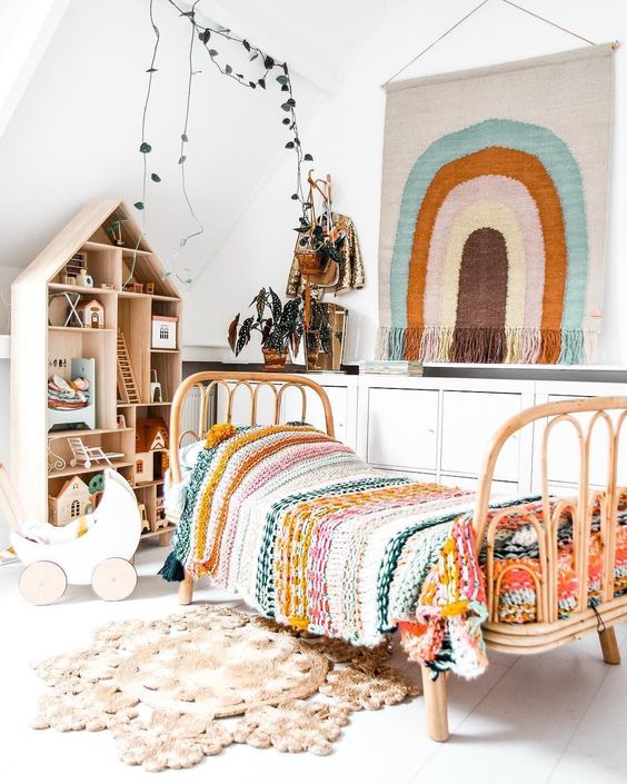 a neutral boho bedroom with bright touches, a rattan bed, a playhouse, a colorful hanging, bright bedding, potted greenery