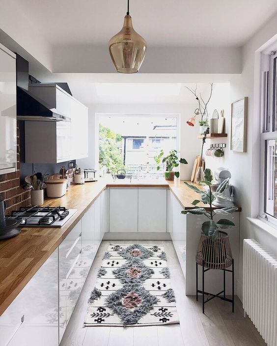 https://www.digsdigs.com/photos/2012/02/a-pretty-small-kitchen-with-white-cabinets-butcherblock-coutnertops-potted-plants-and-a-printed-rug.jpg