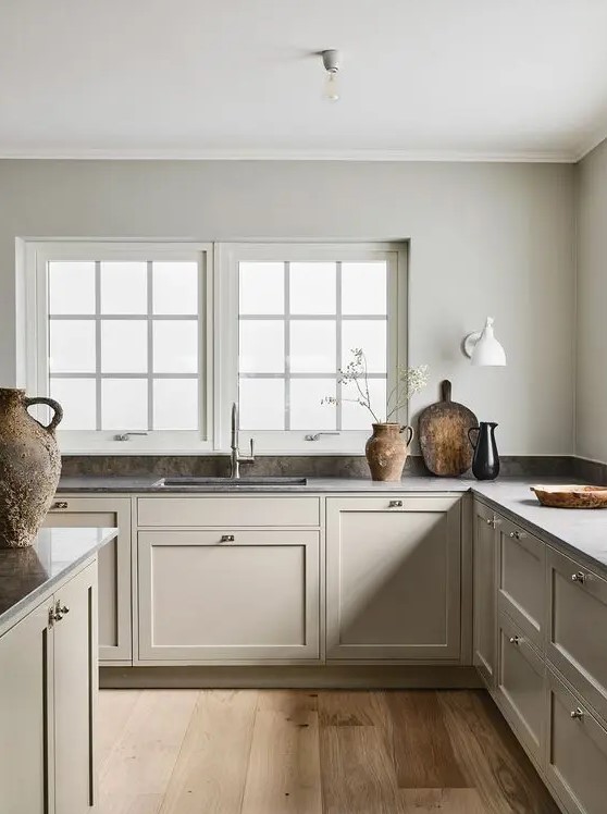 a refined Nordic L-shaped kitchen with a grey stone backsplash and countertops is very calming and soothing