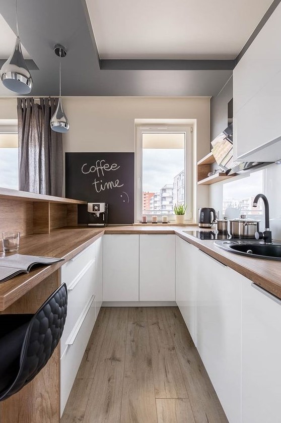 a sleek white kitchen with butcherblock countertops, open shelves and cabinets and a bar counter and workspace in one