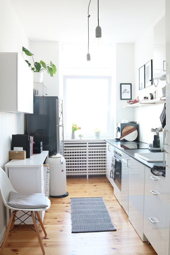a stylish Scandinavian kitchen with black countertops, a black fridge, open shelves and a mini kitchen island