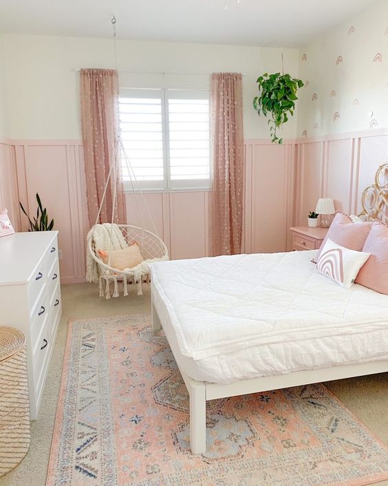 a sweet pink girl's room with paneling, a bed with white and pink bedding, pink polka dot curtains, a white dresser
