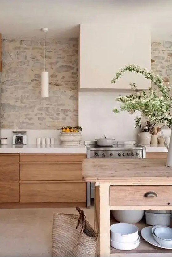 a welcoming kitchen with sleek stained cabinets, white countertops and a stone wall as a backsplash, a wooden table as a kitchen island