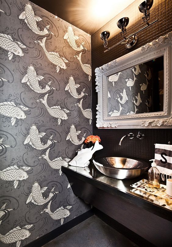 a black powder room with koi fish wallpaper, a black vanity, a mirror in a chic frame, a shiny bowl sink and lights