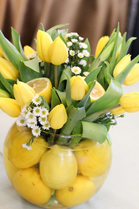 a bold spring or Easter centerpiece of lemons, yellow tulips and white fillers is a cool and bold decor idea to rock